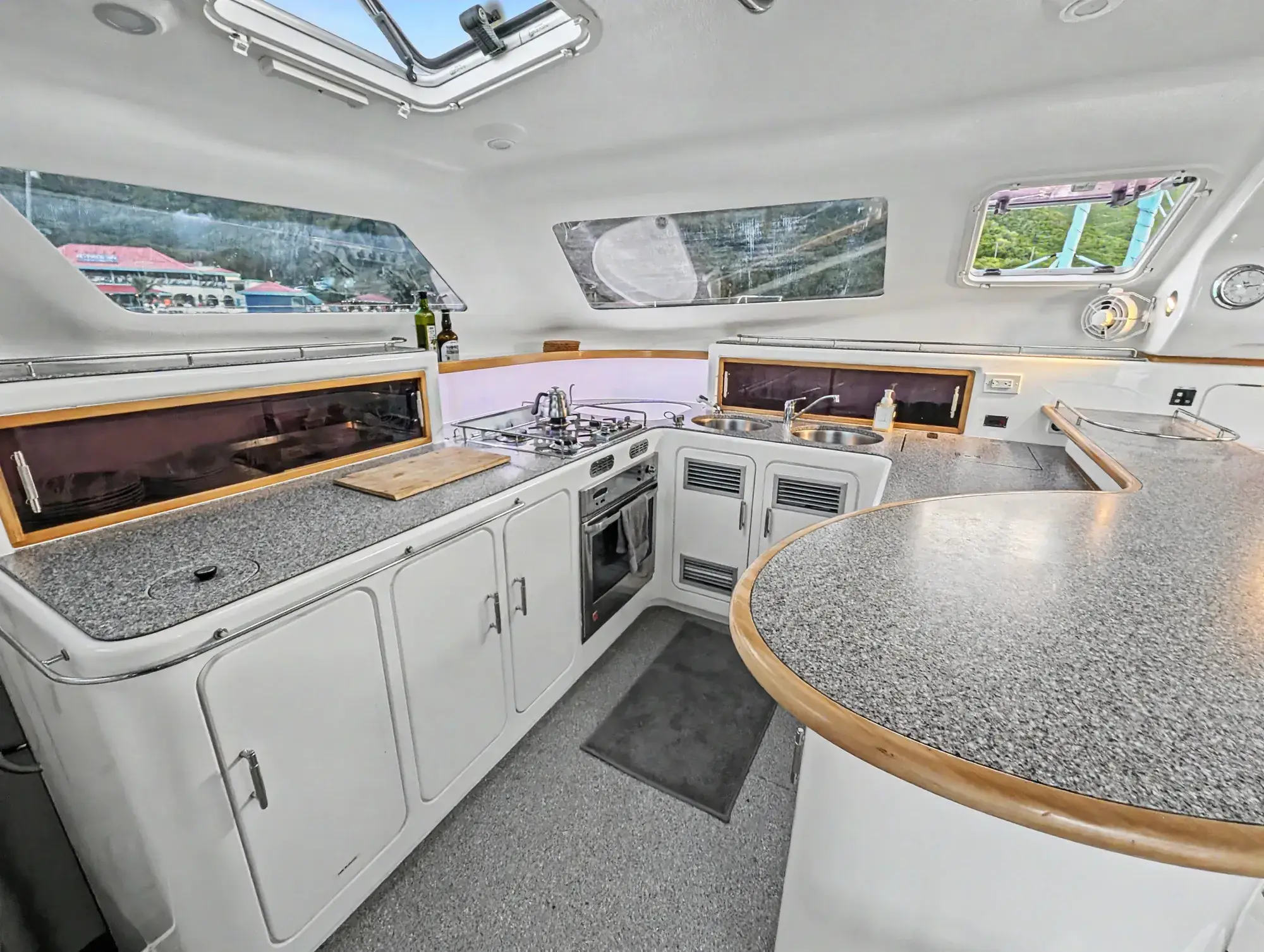 Voyage 500 catamaran galley — U-shaped counter with propane stove, oven, and bar seating for four