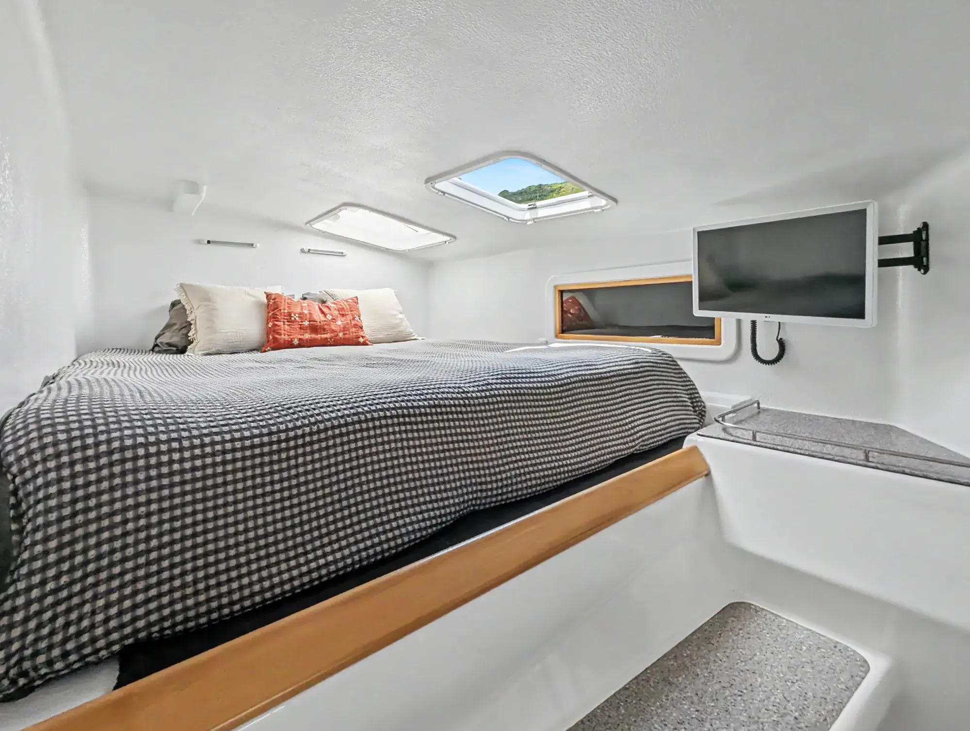 Voyage 500 owner's cabin — king berth in the starboard hull, with new king mattress, hatches, and reading lights
