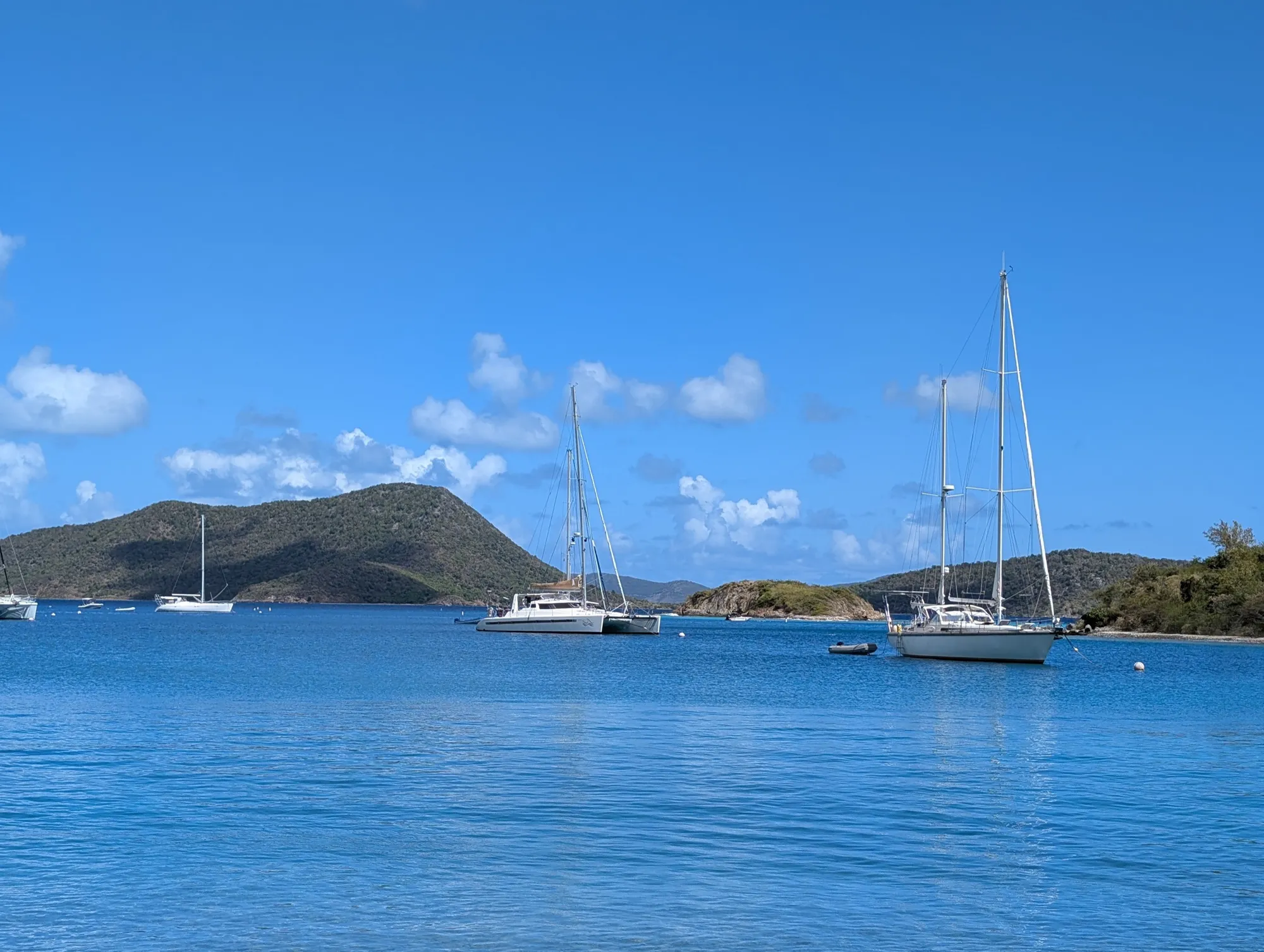 Voyage 500 catamaran anchored in a calm Caribbean bay surrounded by green hillsides