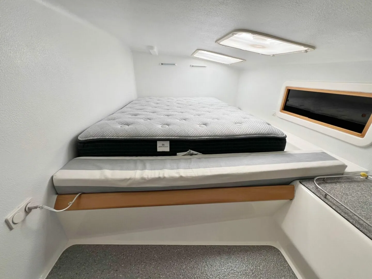 Voyage 500 owner's cabin with queen-sized berth, overhead hatches, and natural light
