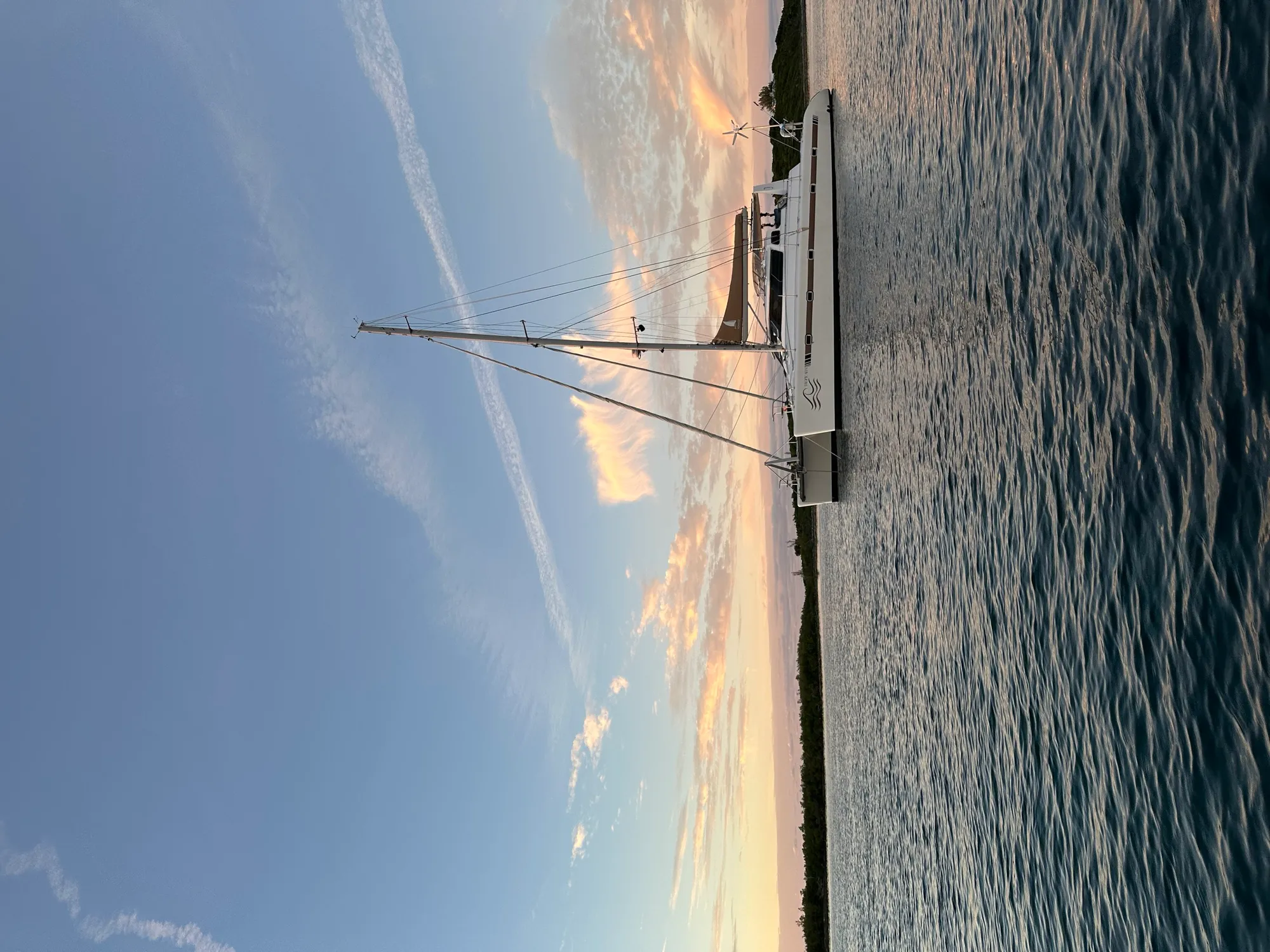 Voyage 500 catamaran under full sail on blue ocean waters with trade winds filling the sails